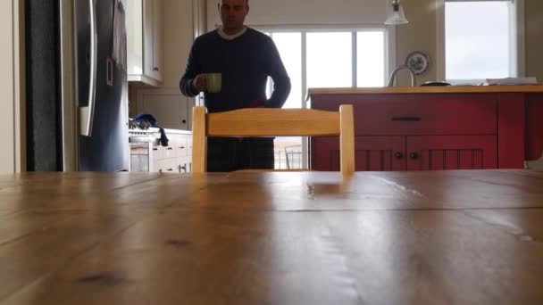 Een man gaat zitten aan een tafel met koffie — Stockvideo