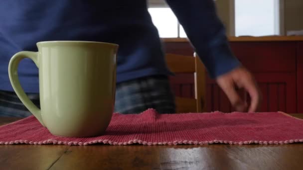 Мужчина садится за стол с кофе — стоковое видео