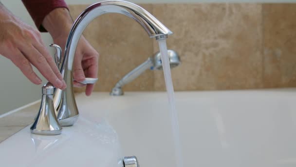 A man turns the faucet handle — Stock Video