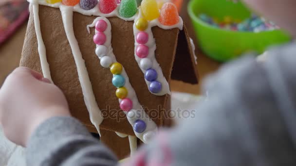 A mother and son decorating a gingerbread house — Stock Video