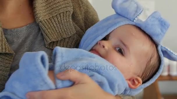 Мать держит своего мальчика завернутого в полотенце — стоковое видео