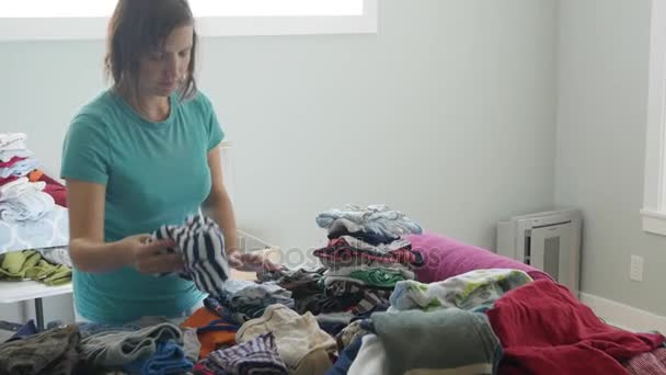 Madre clasificando a través de su ropa de niños — Vídeos de Stock
