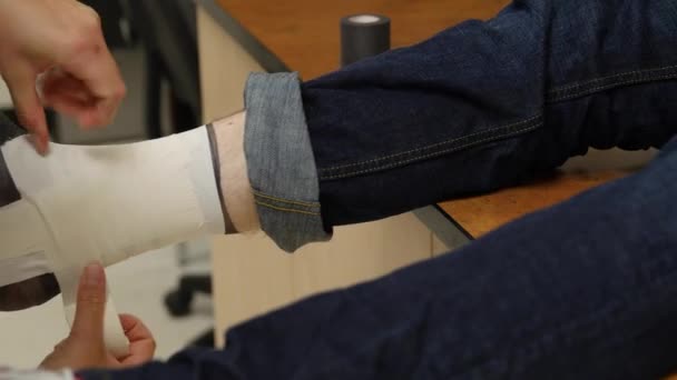 Enfermeira grava um menino torcido no tornozelo — Vídeo de Stock