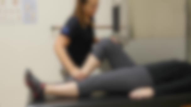 Enfermera streching chica pierna — Vídeo de stock