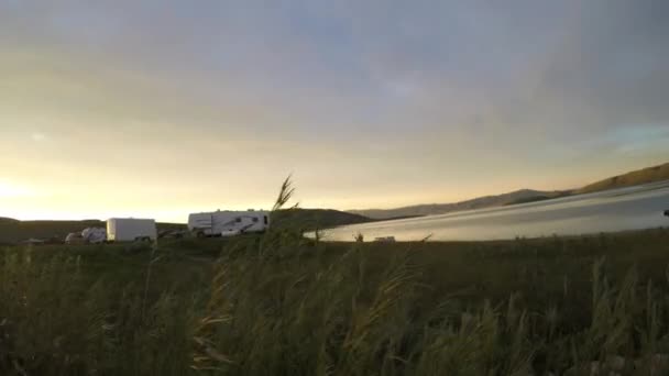 Les gens qui pêchent sur un quai à un lac en soirée — Video