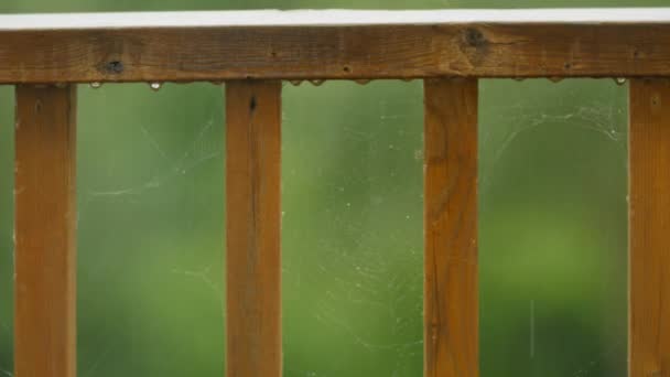 Dešťové kapky dopadající na dřevěná paluba zábradlí — Stock video