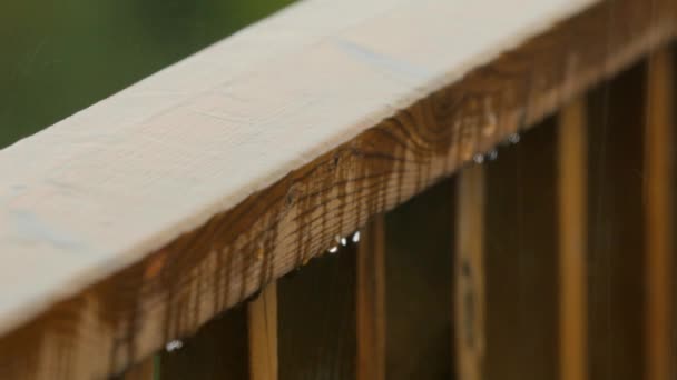 Gotas de lluvia cayendo sobre barandilla de madera — Vídeos de Stock