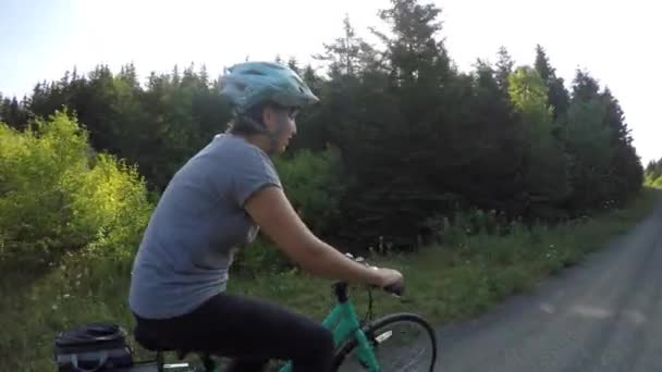 Mujer montando en un carril bici en el bosque — Vídeo de stock
