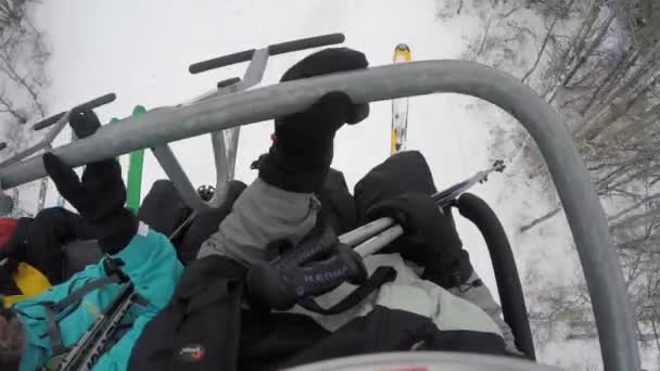 Лыжники слезают с подъемника — стоковое видео