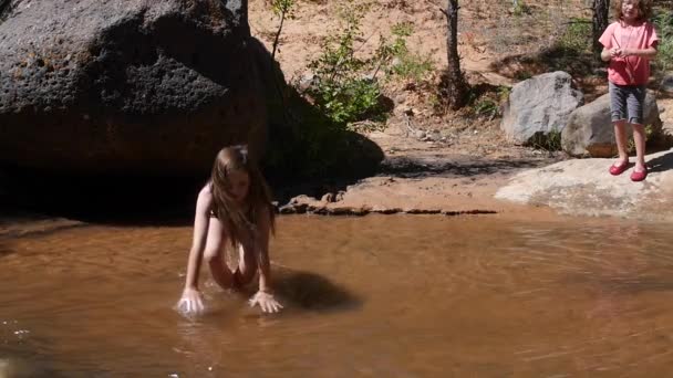 Menina jogando no deserto fluxo — Vídeo de Stock