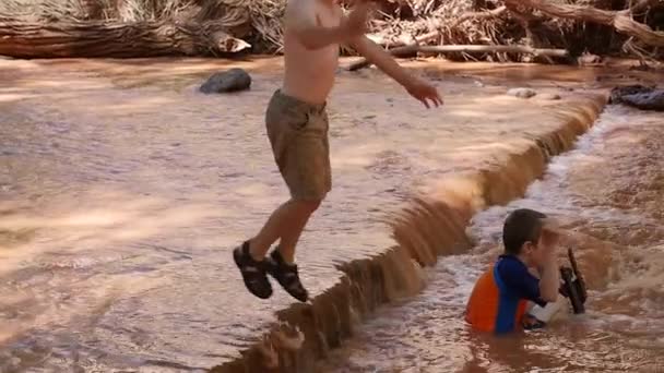 Crianças brincando em um rio deserto — Vídeo de Stock