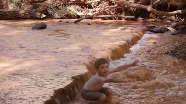 Bambino che gioca nel fiume deserto — Video Stock