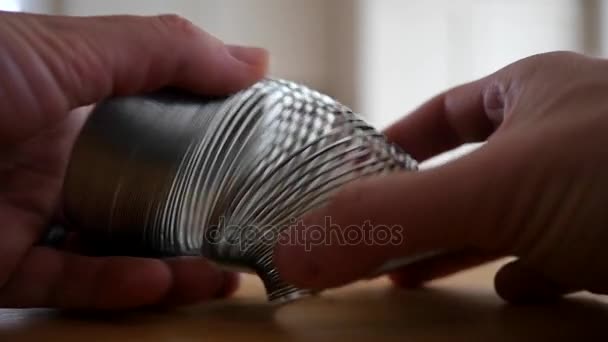 Mãos de homem brincando com um slinky — Vídeo de Stock