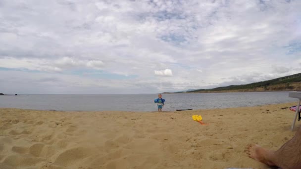 Família sentados em uma praia do oceano juntos — Vídeo de Stock