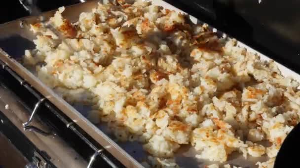 Человек готовит картофельные оладьи во время похода — стоковое видео