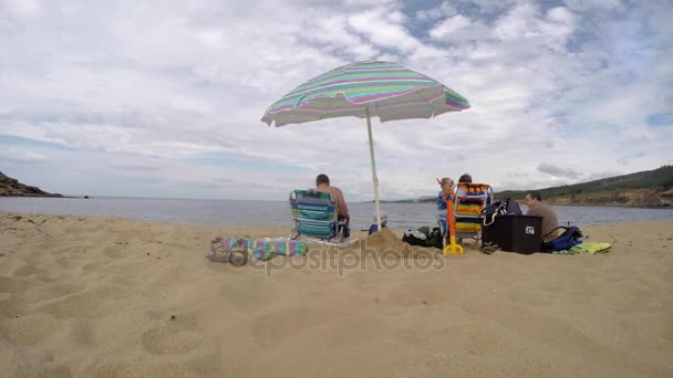 Familie sitzt zusammen am Strand des Ozeans — Stockvideo