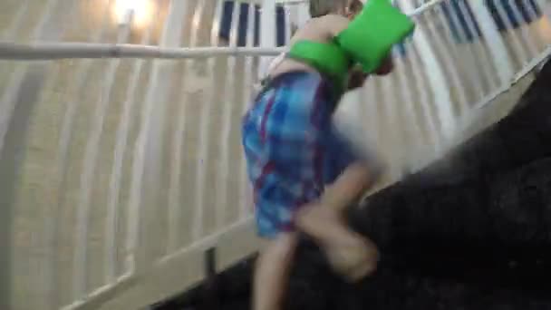 Pojke och far går ner vattenrutschbana — Stockvideo