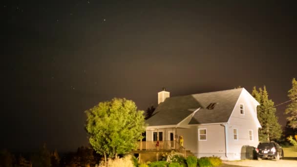 Estrellas y nubes moviéndose sobre la casa por la noche — Vídeos de Stock