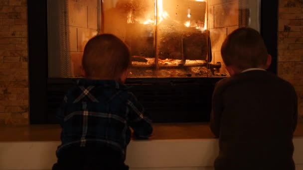 Mali chłopcy, siedząc przy kominku do domu — Wideo stockowe
