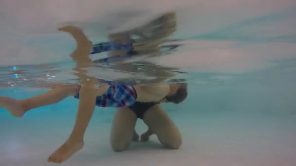 水中ショット少年が彼の背中に浮かぶ — ストック動画