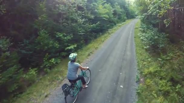 Vrouw fietsen in een forest op fietsweg — Stockvideo