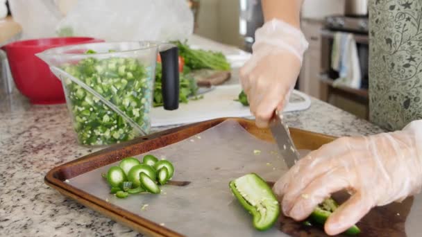 Frau schneidet Jalapenos für Salsa in ihrer Küche — Stockvideo