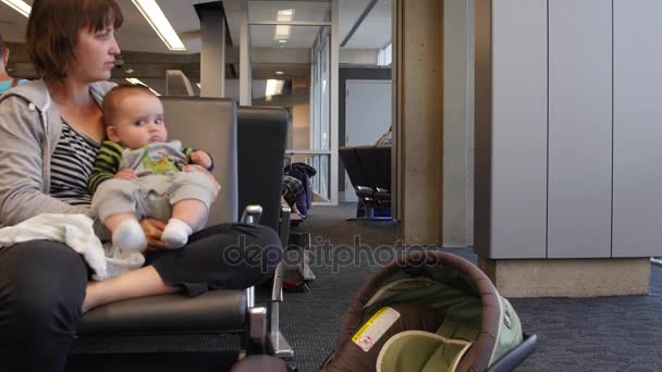 Frau hält Baby am Flughafen — Stockvideo