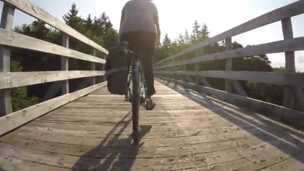 Mujer en bicicleta paseos por el puente — Vídeo de stock