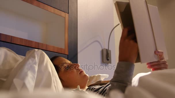 Woman reading a book in a soft bed — Stock Video