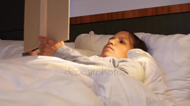 Woman reading her book in a comfortable bed — Stock Video