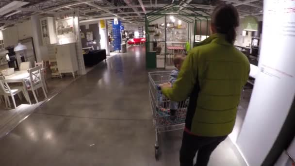 Mulher com seus filhos olhando para móveis na IKEA — Vídeo de Stock