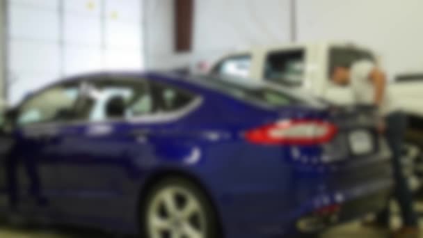Arbeiter reinigen ein Auto in einem Autohaus-Service-Center — Stockvideo