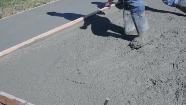 Werknemers een vers gegoten beton patio buiten nivellering — Stockvideo