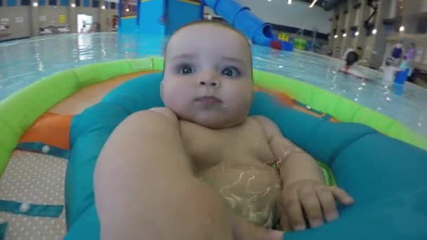 Un bambino galleggiante in una piscina pubblica — Video Stock