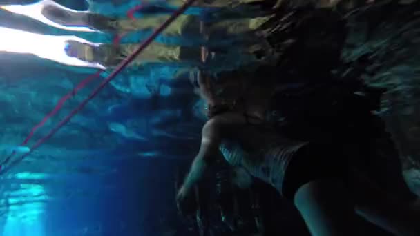 Eine schöne Frau, die in einem unterirdischen Cenote schwimmt — Stockvideo
