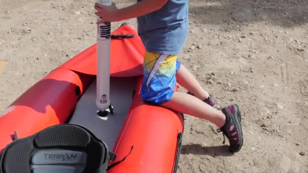 Un ragazzo che pompa un fiume kayak per correre — Video Stock