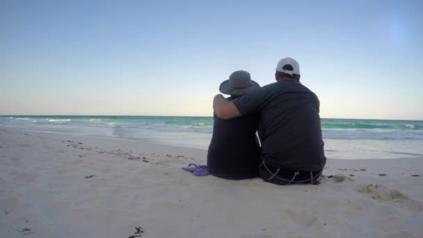 Um casal se senta em uma bela praia tropical — Vídeo de Stock