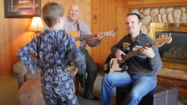 Una familia toca música y los niños bailan — Vídeo de stock