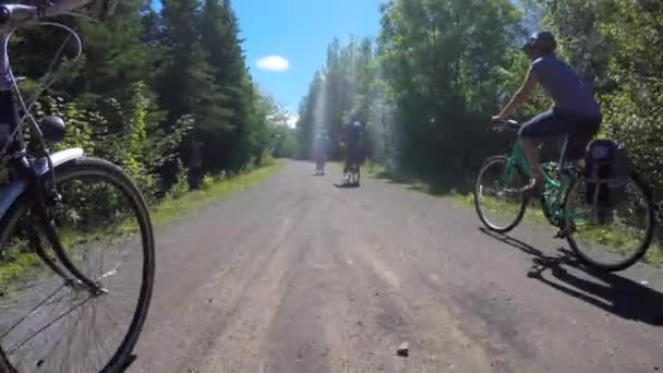 Uma família andando de bicicleta através da floresta — Vídeo de Stock