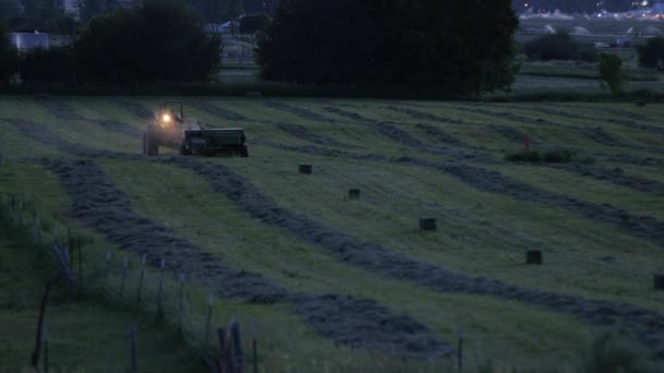 A mezőgazdasági termelő, bailing széna éjjel — Stock videók