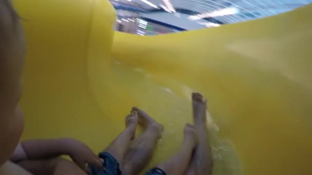 A father goes down water slide with toddler boy — Stock Video