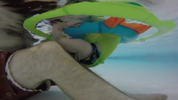 En far med baby flytande i poolen — Stockvideo