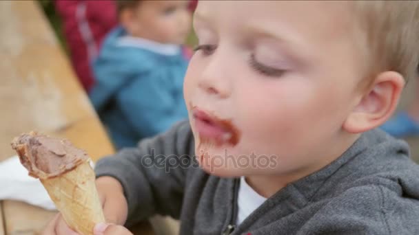 Il ragazzo mangia il gelato in un cono — Video Stock