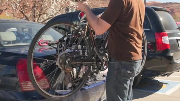 En man sätter cyklar på pakethållare — Stockvideo