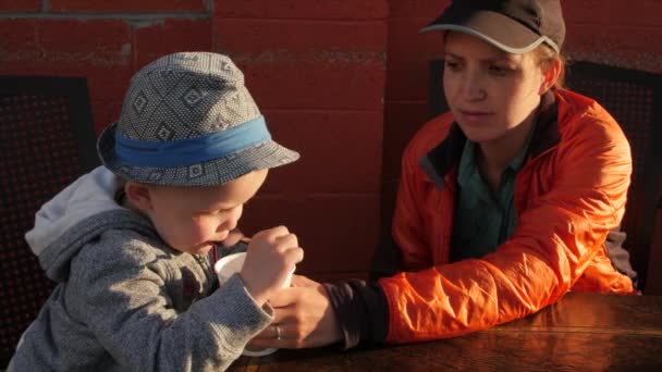 Uma mãe e um menino compartilham um milkshake — Vídeo de Stock