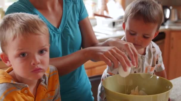 Uma mãe fazendo um bolo com seus meninos — Vídeo de Stock