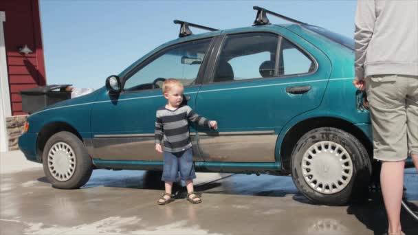 Une mère lave sa voiture avec son mignon bambin — Video