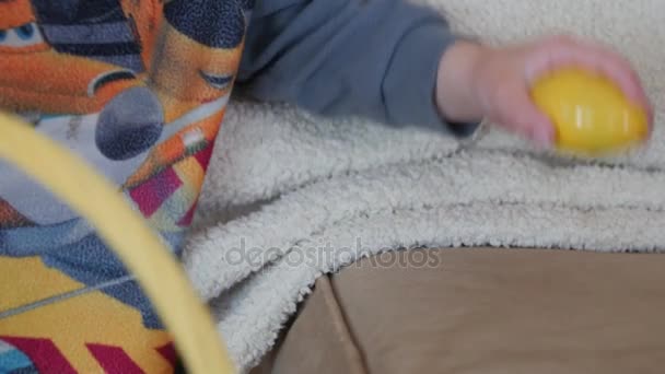 Een peuter jongen vindt een plastic easter egg — Stockvideo