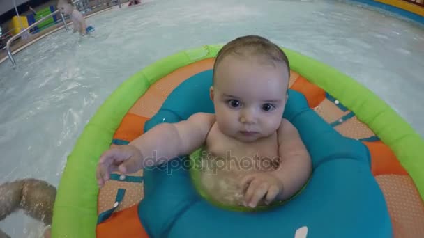 Bébé garçon flottant dans la piscine en famille — Video