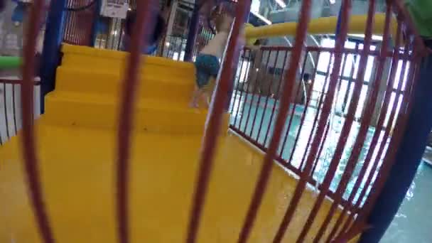 Ένα μικρό παιδί αγόρι παίζει σε κλειστό υδάτινο πάρκο πισίνα — Αρχείο Βίντεο
